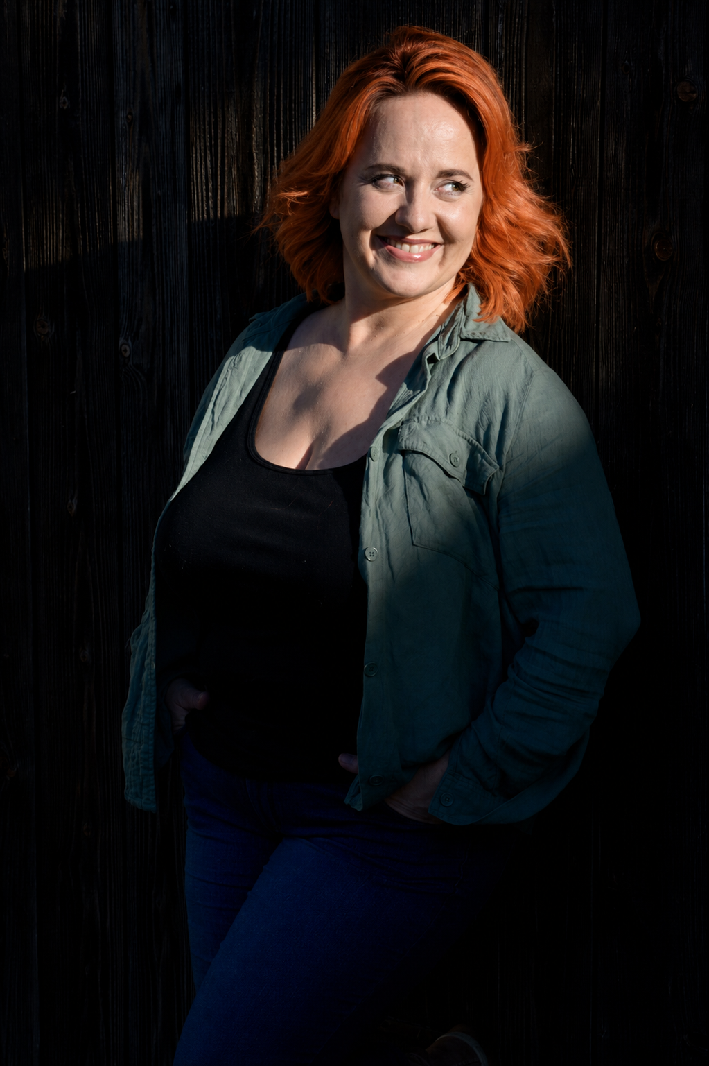Justyna Karpinski lächelnd vor einer Holzwand
